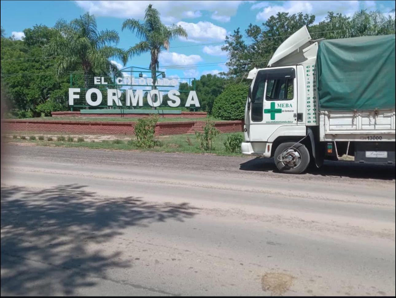Camión de Amoblamientos MEBA entregando mobiliario junto al cartel de acceso a El Colorado, Formosa