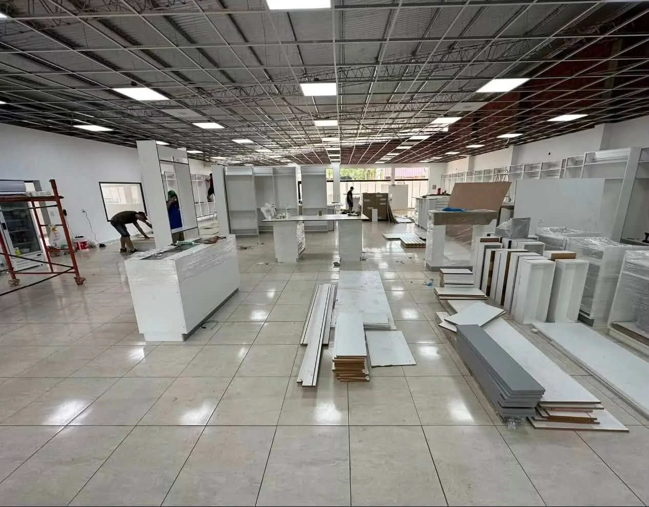 Montaje del mobiliario en obra: mostradores y paneles de melamina embalados antes de la instalación final.