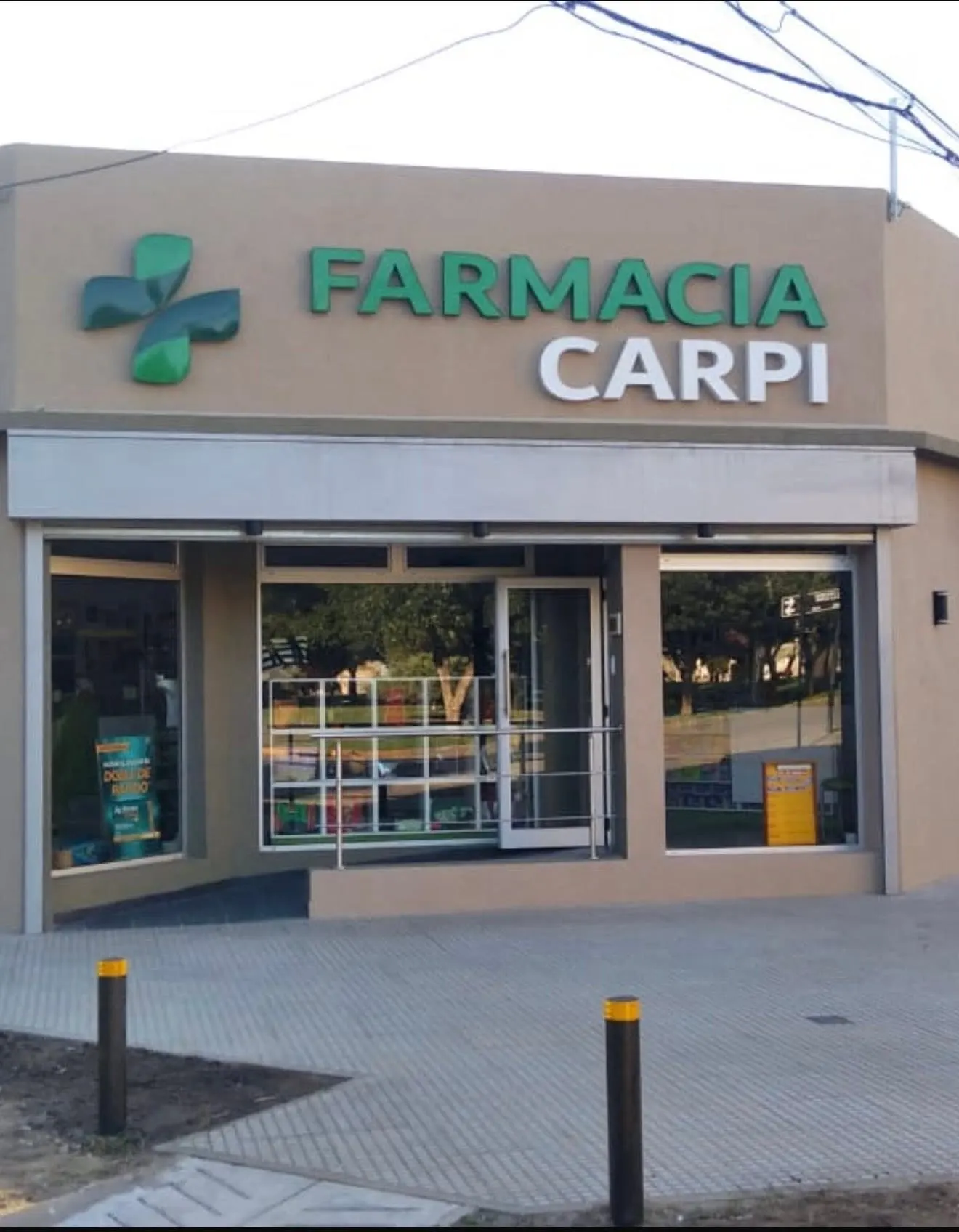 Fachada de Farmacia Carpi con cartel institucional y cruz farmacéutica en la entrada.