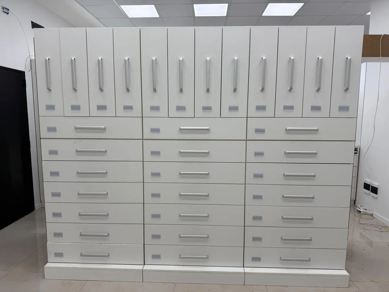 Frente de cajoneras y alacenas del sector de recetario, con puertas rebatibles y tiradores de aluminio.