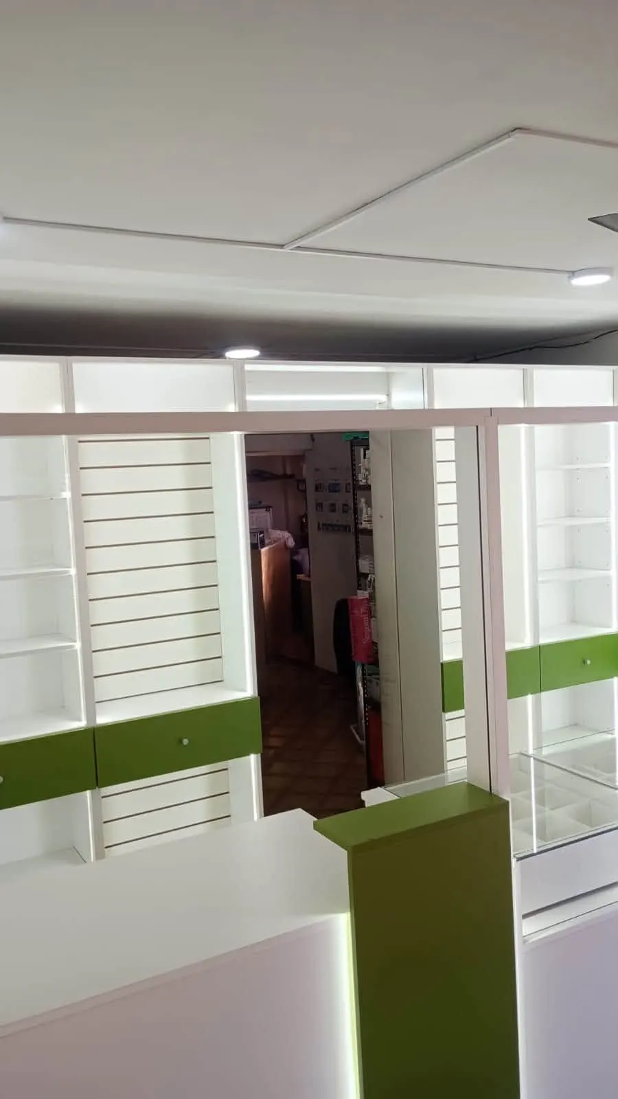 Vista hacia el depósito y sector interno, con estanterías perimetrales y cajones verdes.