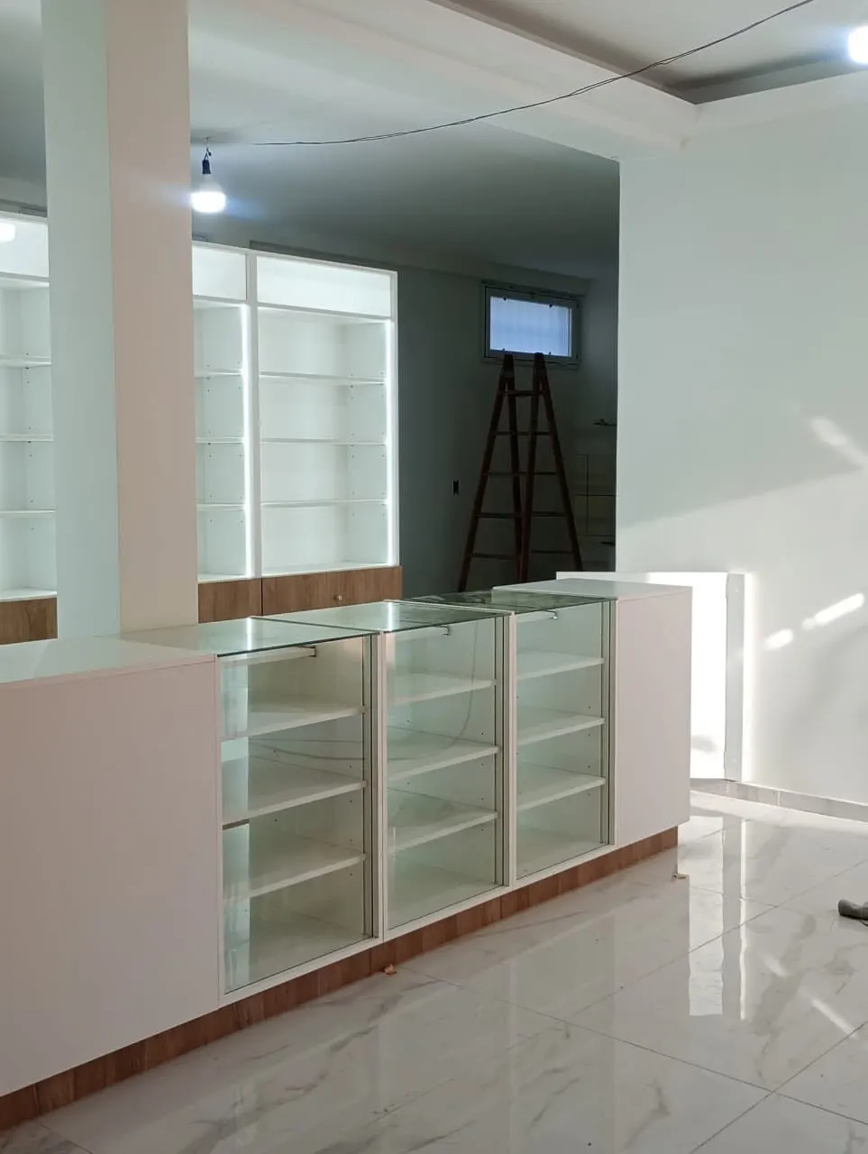 Vitrinas modulares con puertas de vidrio y zócalo en melamina símil madera, listas para reponer mercadería.