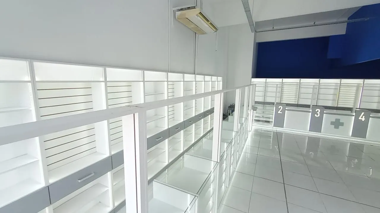 Vista en altura del salón con estantería perimetral, puestos numerados y sector de cajas.