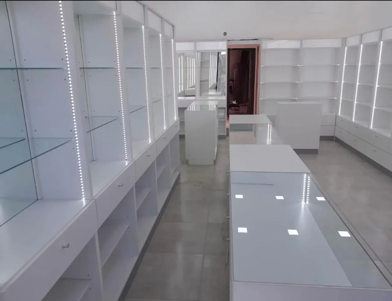 Línea de mostradores con cajoneras, repisas voladas y puesto de atención numerado.