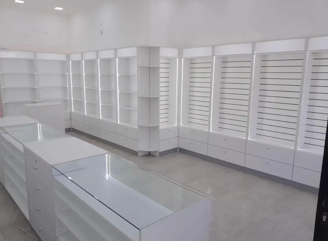 Vista en altura del salón con estantería slatwall y puestos de atención numerados.