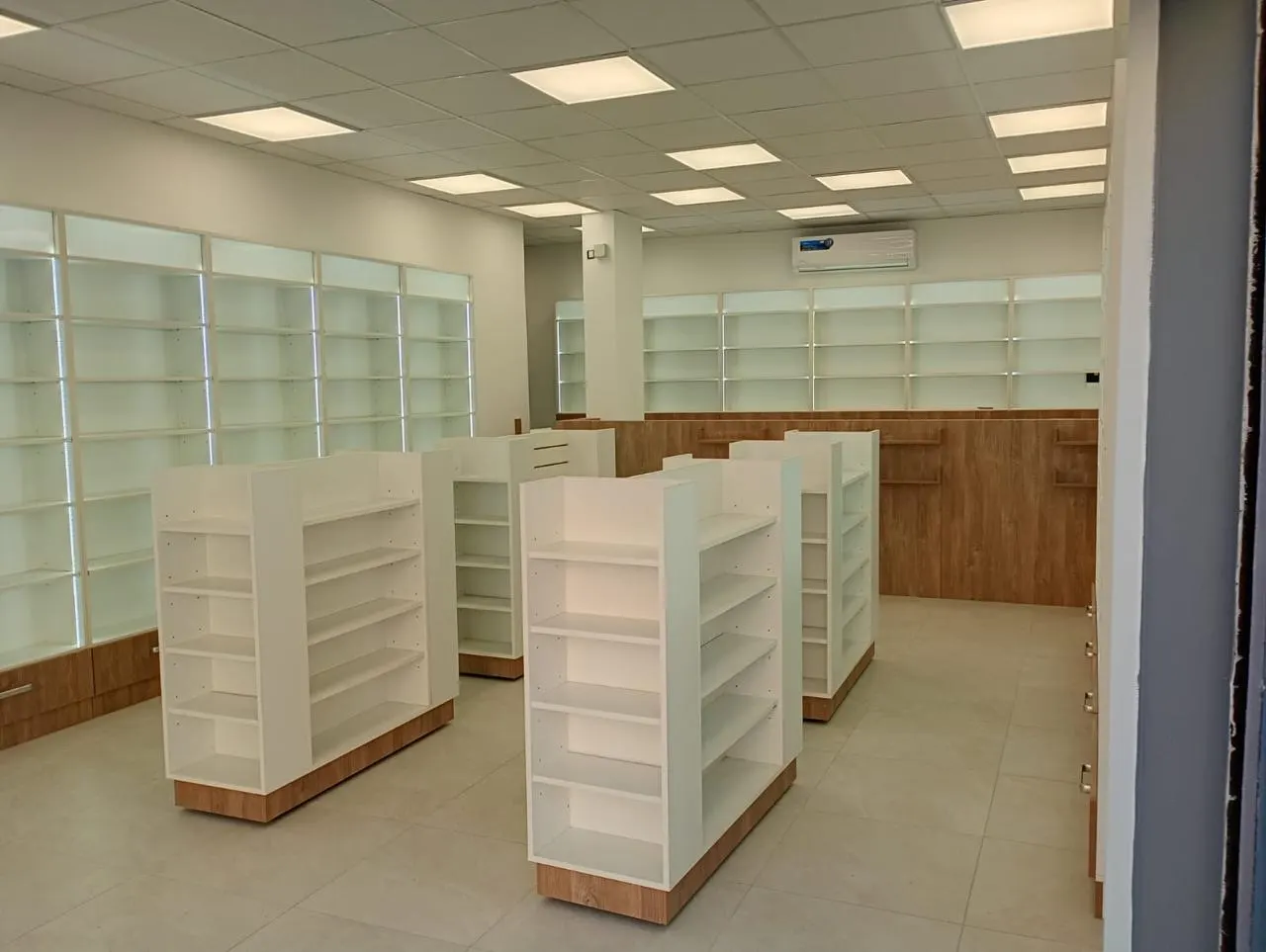 Vista amplia del salón con líneas de venta, sector de indumentaria infantil y estanterías perimetrales iluminadas.